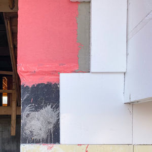 EIFS system pictured in layers as applied to an actual exterior wall.