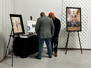 People standing in front of the Majesty Project's table at an art auction in Joplin, MO