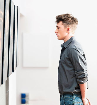young man standing in front of wall art