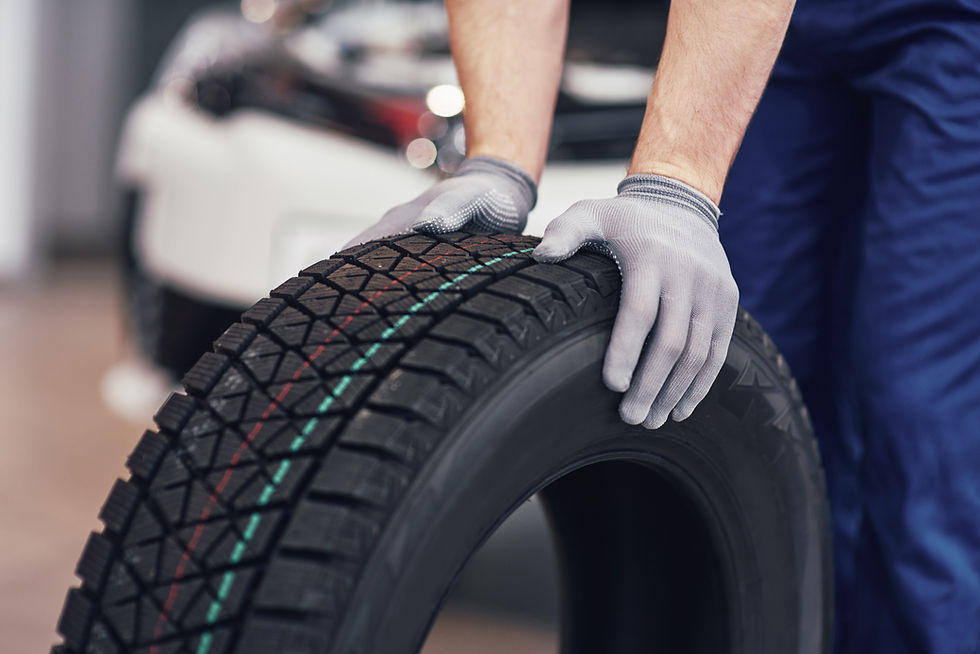 closeup-mechanic-hands-pushing-black-tire-workshop.jpg