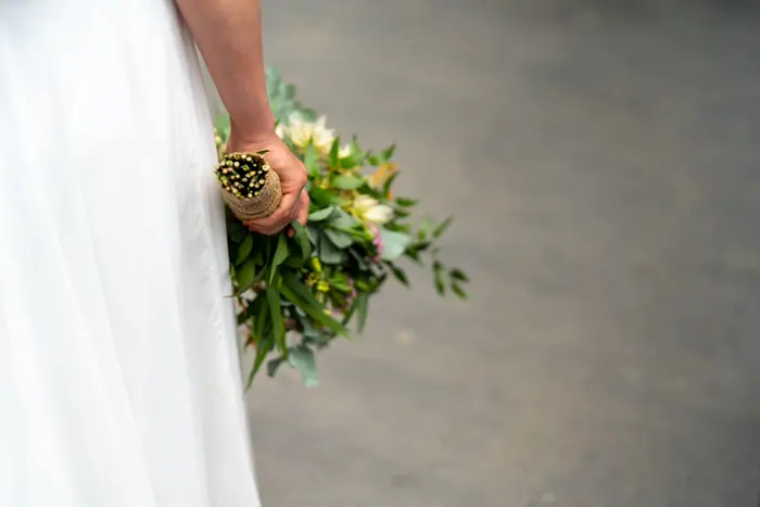 Une mariée qui tient un bouquet de fleurs