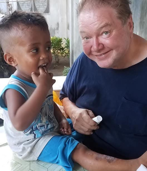 A caring moment between a supporter and a child in the Philippines, reflecting mentorship, encouragement, and hope for a brig