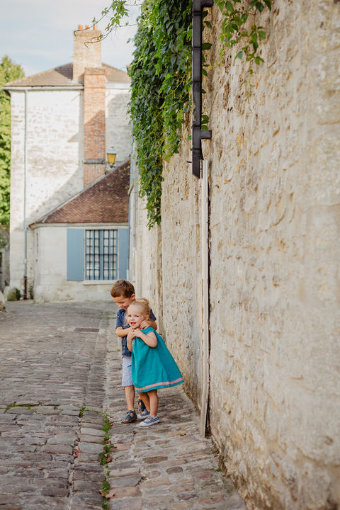 un petit garçon tient dans ses bras sa petite soeur dans les ruelles de Senlis