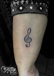 Treble clef music tattoo on arm Sundernagar