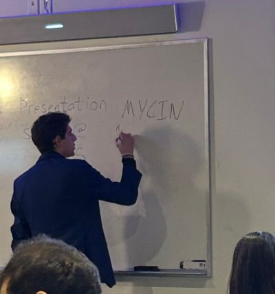 Writing on whiteboard while teaching Introduction to AI