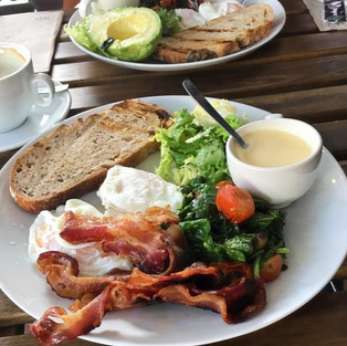 Plate with bacon, eggs, fresh spinach poached eggs at Maleva sourdough bread bakery in Marbella