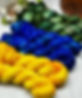 A six skein set of yarn, two skeins of yellow, two skeins of blue and two skeins of green, on a white backdrop
