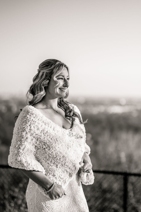 black and white image of a smiling woman in a bridal gown and shawl