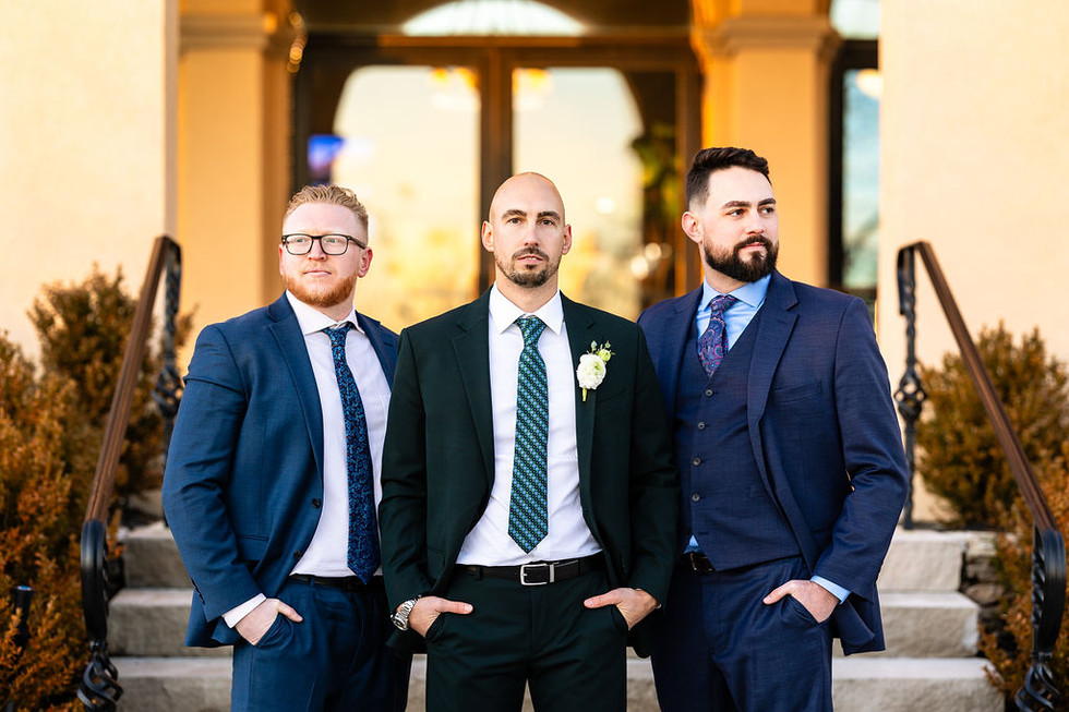 portrait of groom and groomsmen in front of The Highlawn