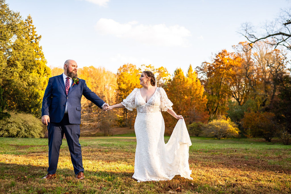 bride and groom posing in front of fall trees at Tyler Arboretum in Media, Pennsylvania