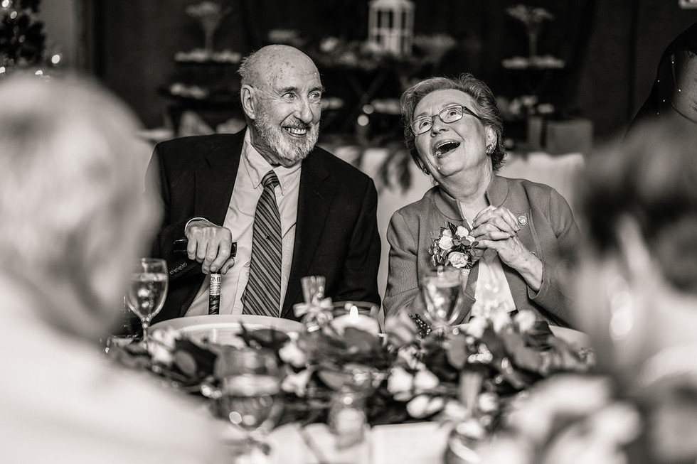 old couple smiling at a table with of family
