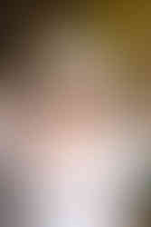 a bride in a wedding gown holding a bouquet of flowers in front of a stone building at Tyler Arboretum in Media Pennsylvania