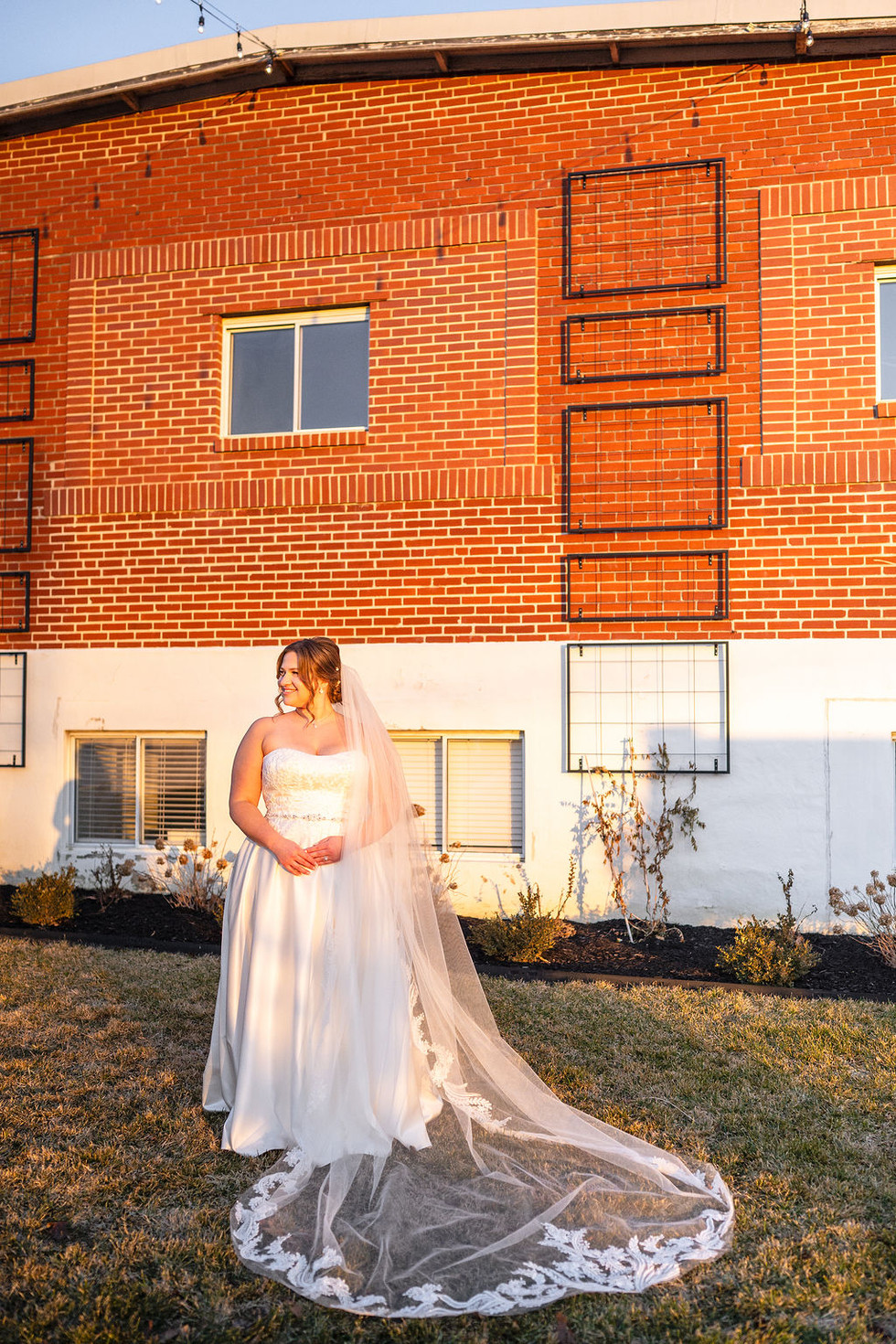 a bride in a white gown and long veil posing in front of Lincoln Shoe Co. in Lititz Pennsylvania