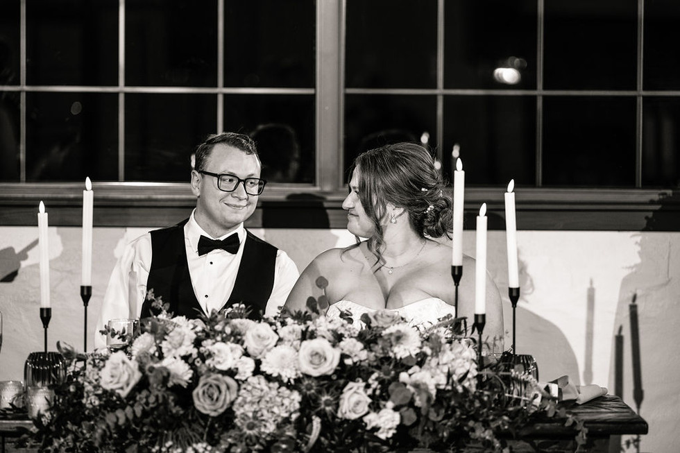 bride and groom smiling at each other at their table  at Lincoln Shoe Co.  in Lititz Pennsylvania