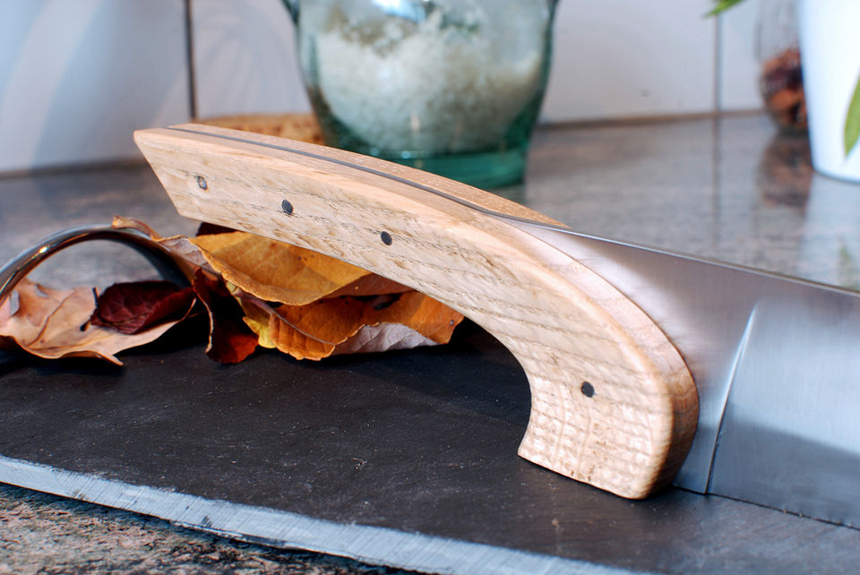 Couteau de cuisine artisanal qui tient sur sa tranche manche en bosi d'olivier