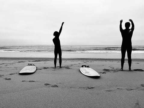 Surfers warming up on the beach before a surf session near Ericeira with Vivenda Felicidade coliving community from Sintra
