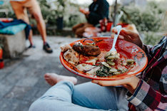 Colivers sharing a farm-to-table dinner around a bonfire at Vivenda Felicidade, enjoying local food and traditional Portuguese pottery in a regenerative community setting near Sintra.