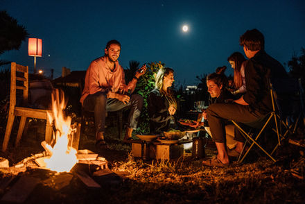 Community gathering around a bonfire under the full moon at Vivenda Felicidade coliving in Sintra, enjoying farm-to-table food and regenerative living.