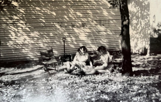 Two young girls in the backyard making mud pies