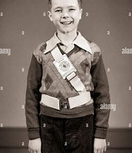 Young boy with crossing guard safety belt from the 1950s