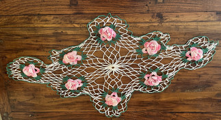 doily with raised pink flowers on top of chest