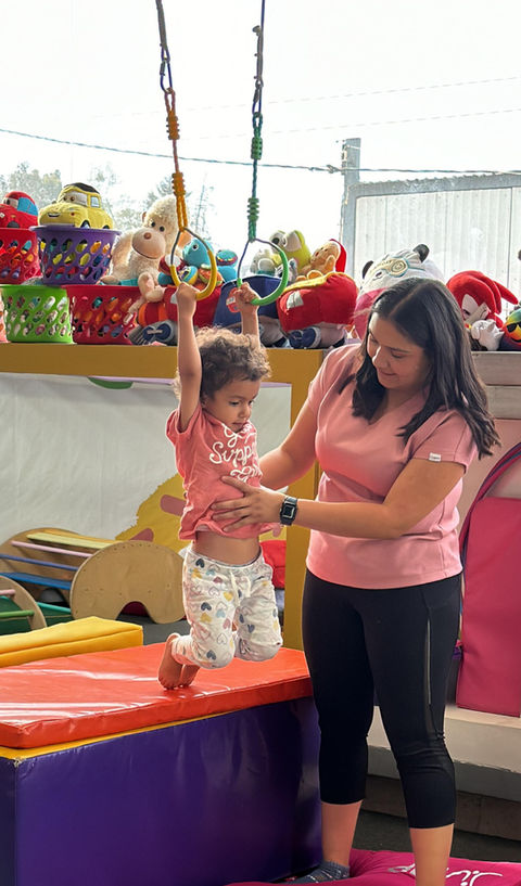 Una alumna del Baby Gym colgándose de los anillos