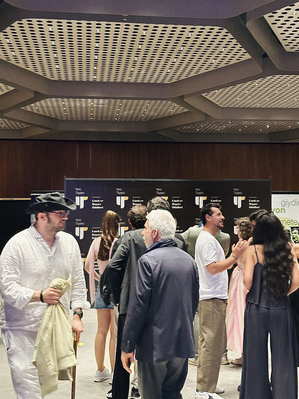 Guests standing in front of the branded backdrop designed for the 13th International Yeni Tiyatro Awards.