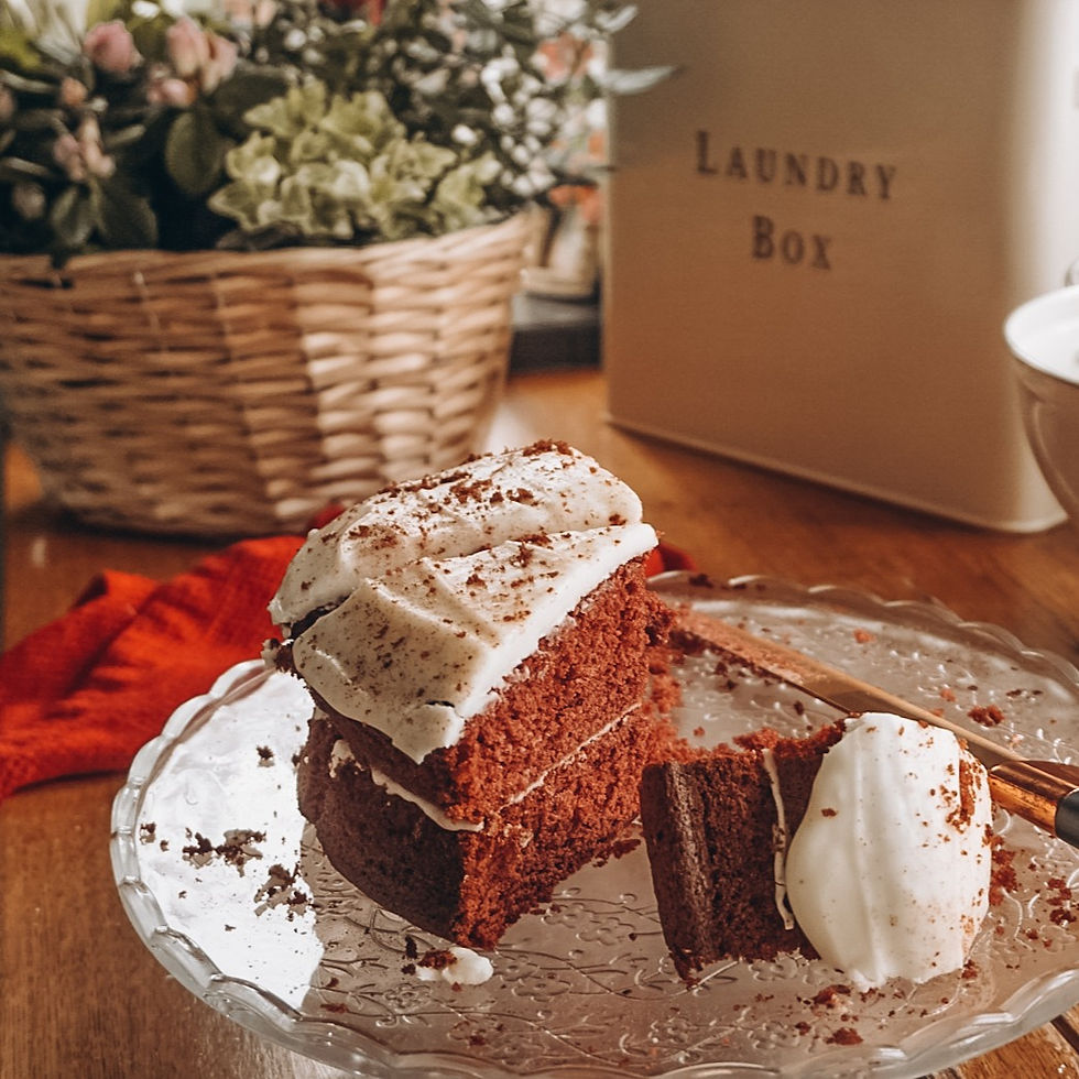 A red velvet cake on a glass tier, with two slices cut