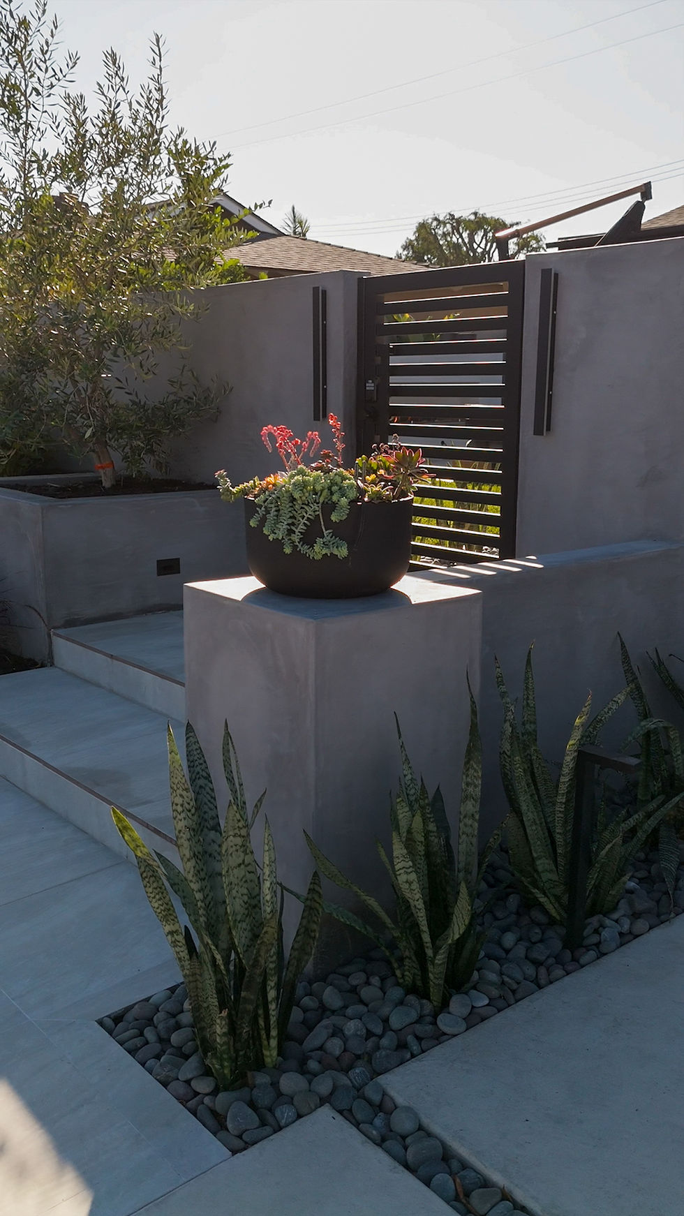 Welcoming front entryway with custom pilasters and potting arrangement, luxury outdoor living design