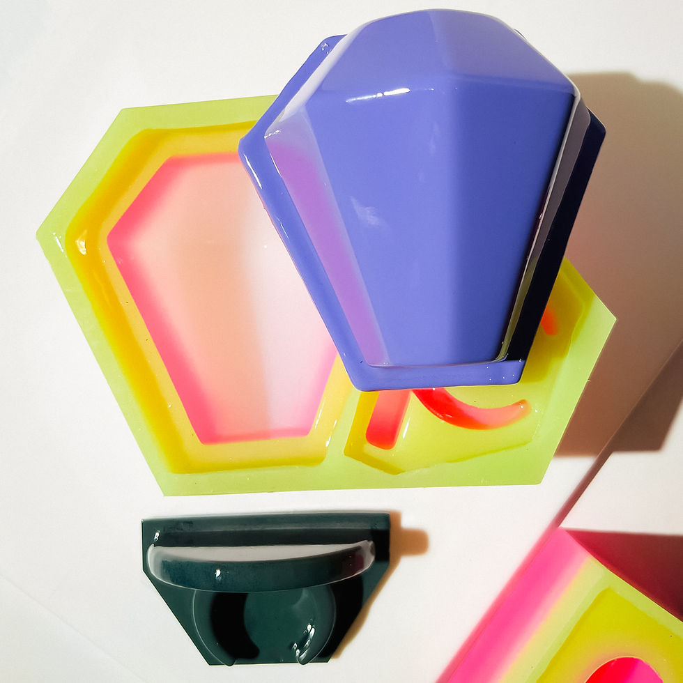 Purple and green Ring Pop master cast shadows on a white surface. A yellow and pink Ring pop adds a vibrant contrast.