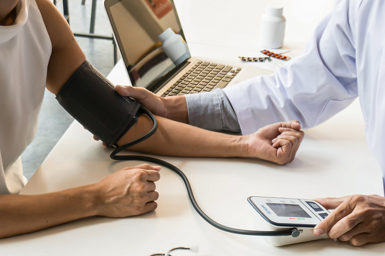 Doctor taking blood pressure of patient