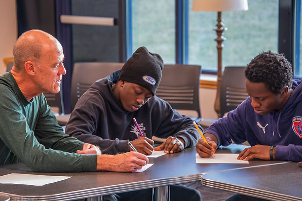 Teacher helping refugee students study