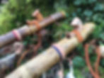 Thumbnail: Handcrafted Native American style flutes made of Bamboo with feathers and stone inlays in a forest setting.