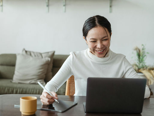 A Virtual Assistang using a laptop and tablet, working remotely in a cozy living room.
