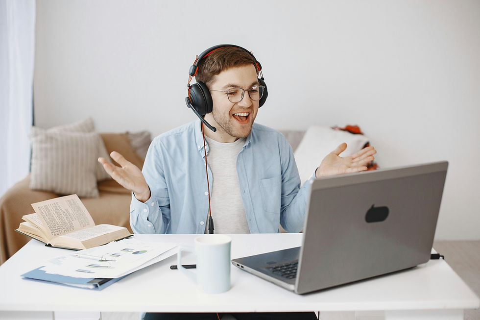 Smiling Virtual Assistant wearing headphones having a video call on a laptop in a home office setting.