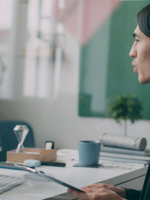 A Virtual Assistant engaged in a video conference in a modern home office setting.