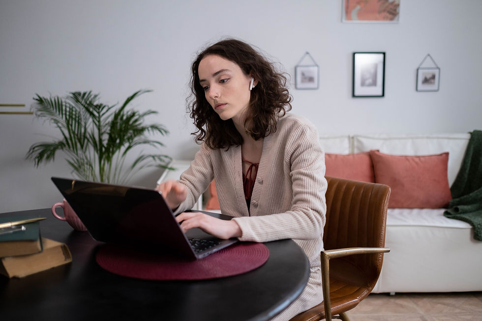 A young Virtual Assistant in a cozy home setting working remotely on her laptop, embodying modern digital nomad lifestyle.