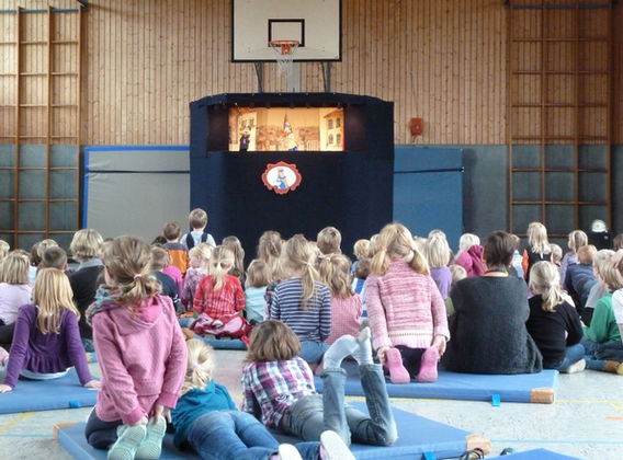Kinder schauen sich das Puppenspiel an