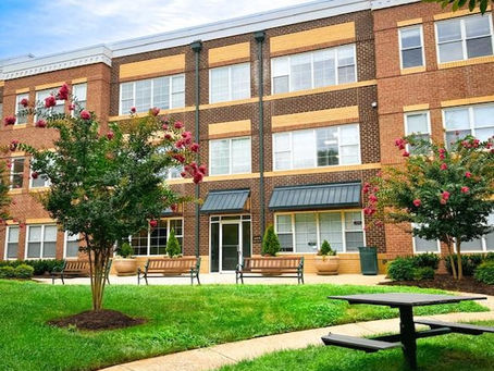 Commercial office building area with grass, blue sky and trees 