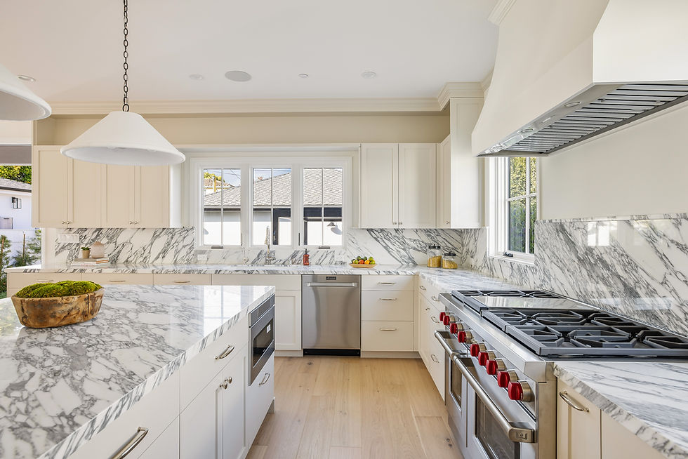 Kitchen with a large center island, four wood counter stools, marble backsplash, and professional range