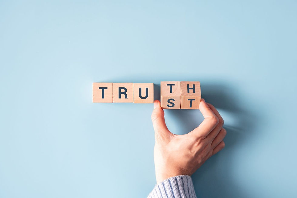A hand spelling out the word Truth/Trust with block letters