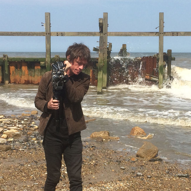 Filming on Happisburgh beach, 2018 a man with a 16mm camera on a beach