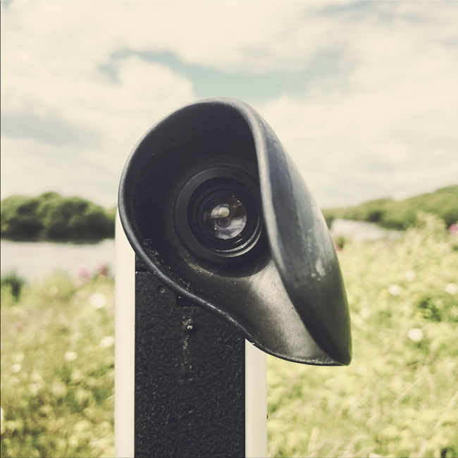 This is a colour Super 8mm film still of an abandoned acoustic mirror at Denge, standing against the vast sky and reflected in the waters of Greatstone Lakes. The weathered concrete structure, once an early warning system for detecting enemy aircraft before radar, now looms as a haunting relic of wartime history. Part of the Sound Mirror project directed by Julian Hand and Heena Song, this image captures the contrast between past and present, blending experimental film techniques with the atmospheric landscape of Dungeness Nature Reserve.