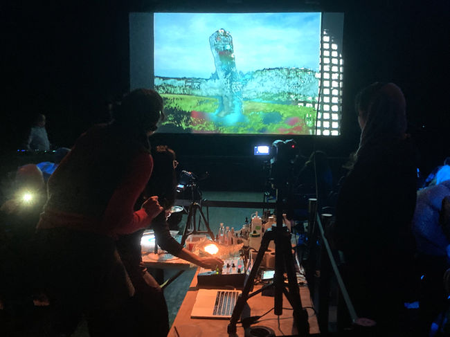 liquid light artwork, projection and photography, a projectionist at work, man projecting liquid on the wall, a band playing live with psychedelic projections. A festival film screening