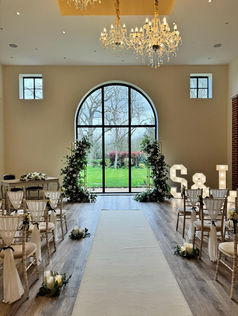 Deconstructed arch, aisle runner and chair decor at Reymerston Hall