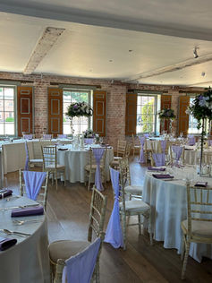Ava Artificial Floral Centrepieces with Added Violet Florals and Chair Drapes - Kimberley Hall