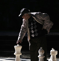 Elderly Man Moving Large Chess Piece