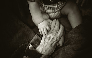 Baby holding elderly hand