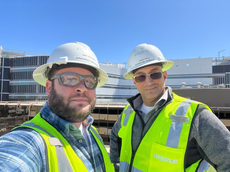 Seth and Sergio in PPE in front of Providence Cedars-Sinai Tarzana Medical Center - medical center façade glass, blue skies