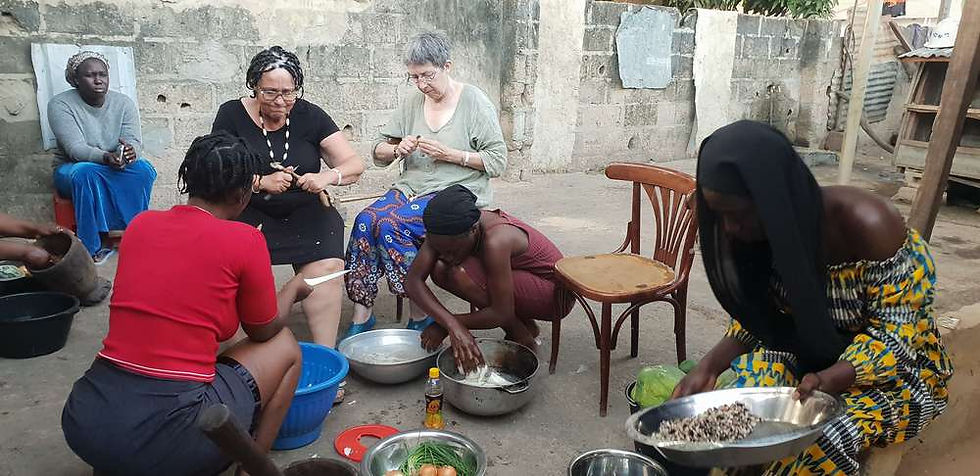 Christine, Bernadette, Fatou et ses sœurs en train de cuisiner dans la cour derrière la maison de Awa